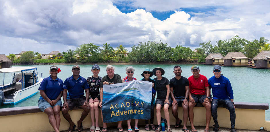 Group of guests hold up a banner during a recent Academy Adventures trip to Fiji