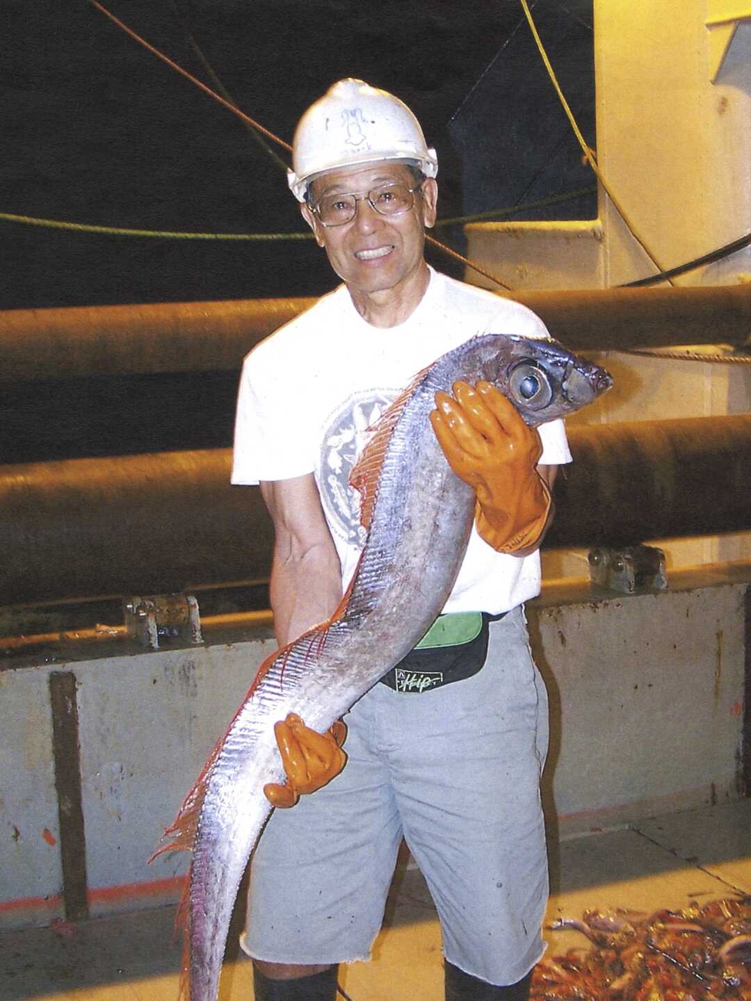 Tomio Iwamoto holds an oarfish on board a research vessel 