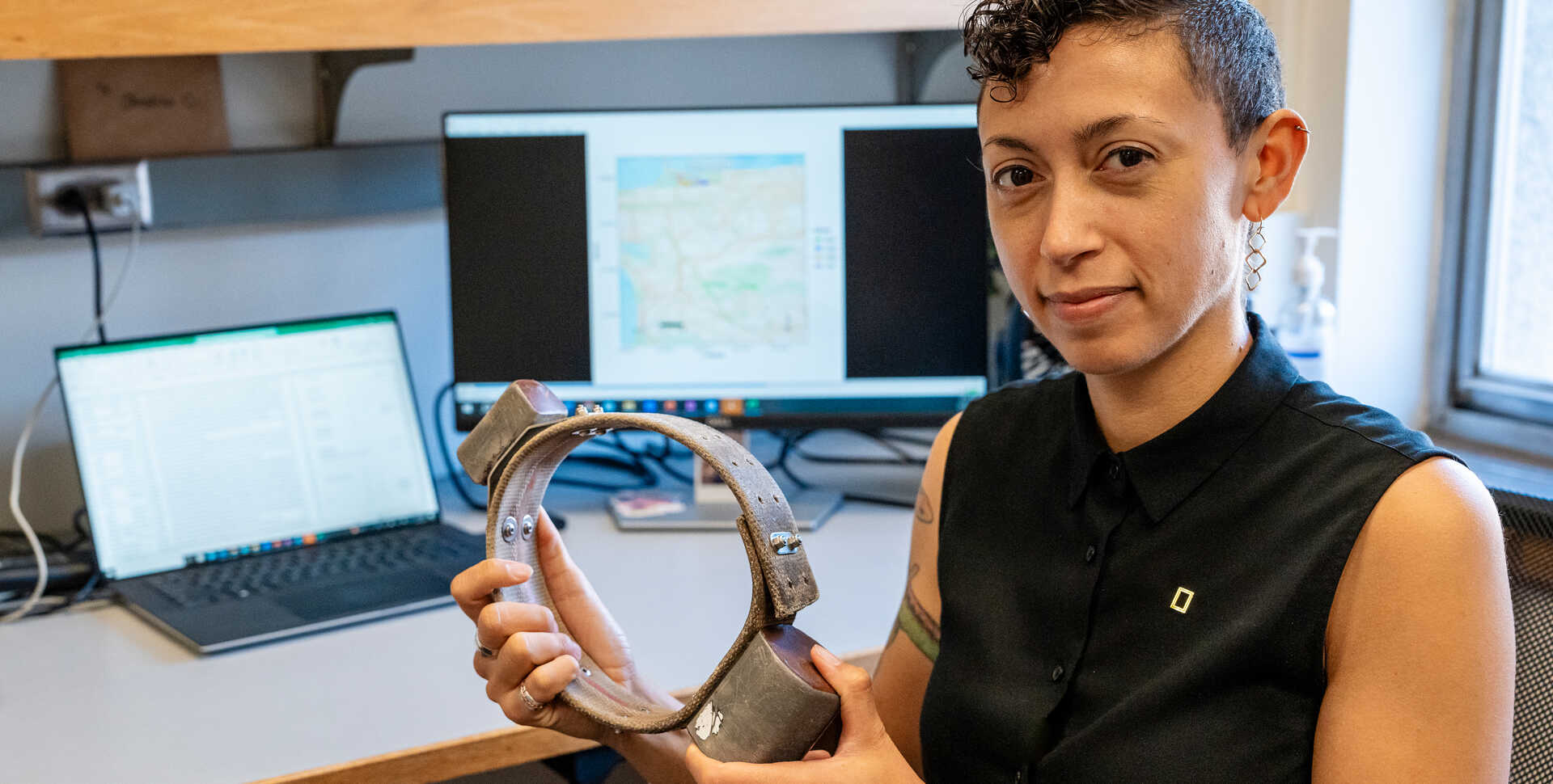 Urban ecologist Dr. Christine Wilkinson holds a coyote radio collar in her office. Photo by Gayle Laird