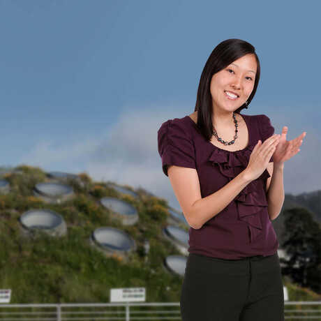 Woman on Academy Living Roof with rainforest dome in background