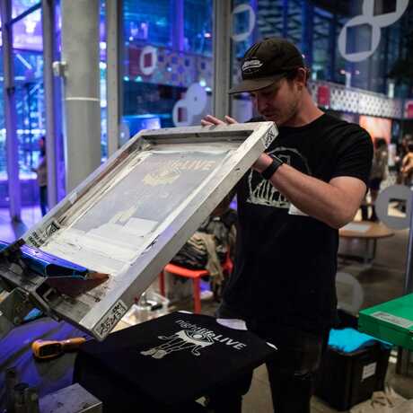 A San Franpsycho employee screen prints a t-shirt at NightLife at the Academy