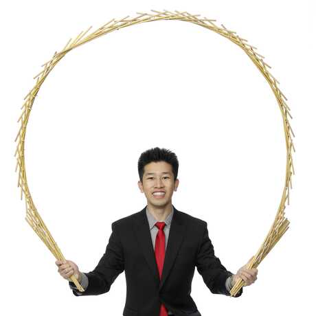 Magician Perry Yan holds a giant arc over his head