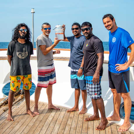 Academy and Maldivian marine scientists and researchers display a mesophotic fish specimen on board