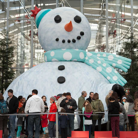 Guests line up to enter the giant Snowman Theater inside the Academy's Piazza