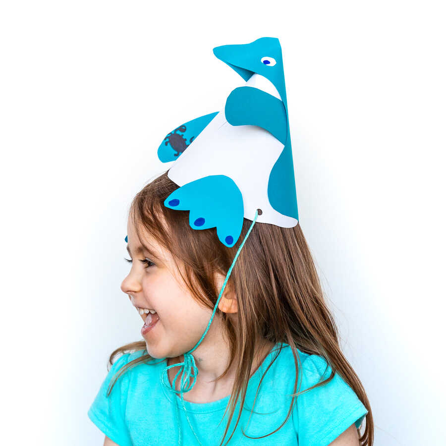 Girl wearing paper penguin party hat