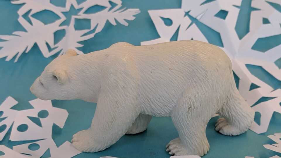 polar bear walking through paper snow flakes