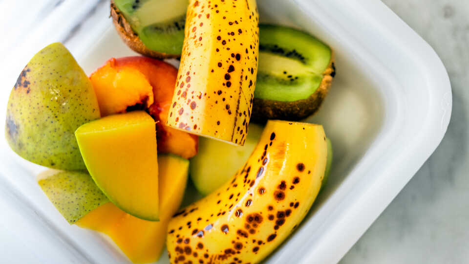 Fruit medley of banana, peach, kiwi, and mango. 