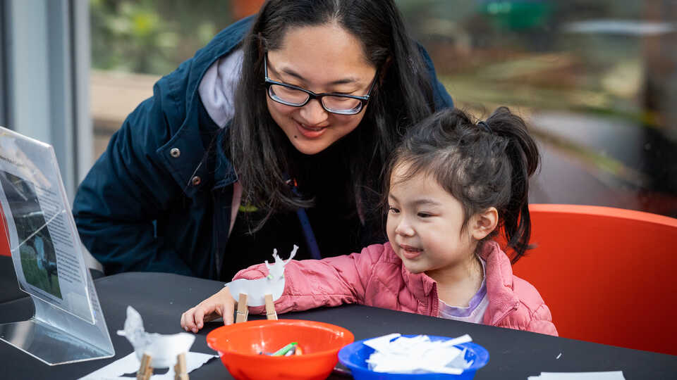 Woman and young girl enjoy making reindeer crafts at the Academy's 'Tis the Season for Science