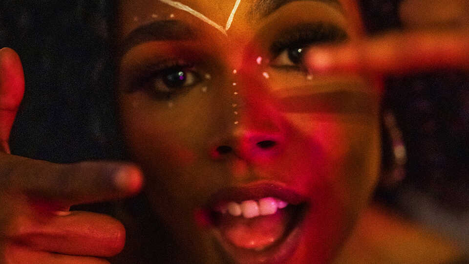 A Black woman in afrofuturist makeup is shown in a close-cropped image.