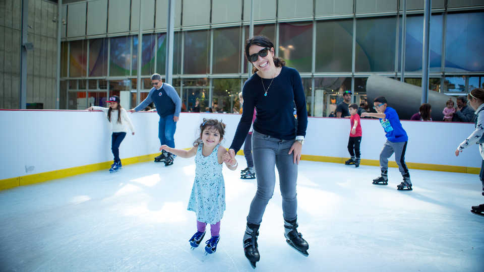 A mother and daughter ice skate at the Academy's holiday ice rink 